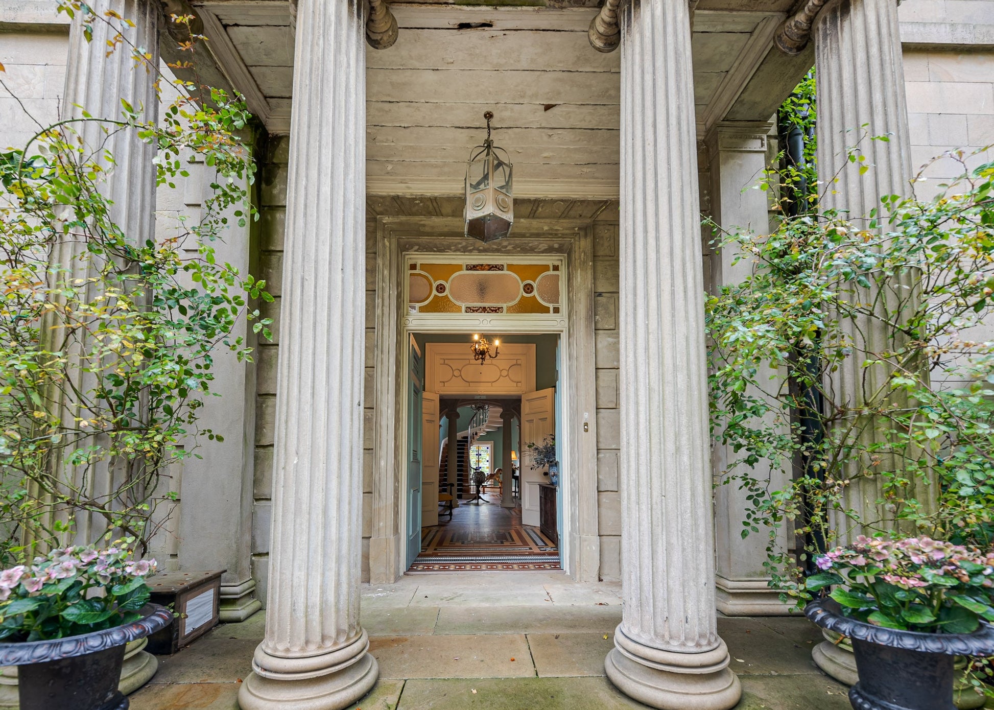  classical architectural entrance with columns and plants
