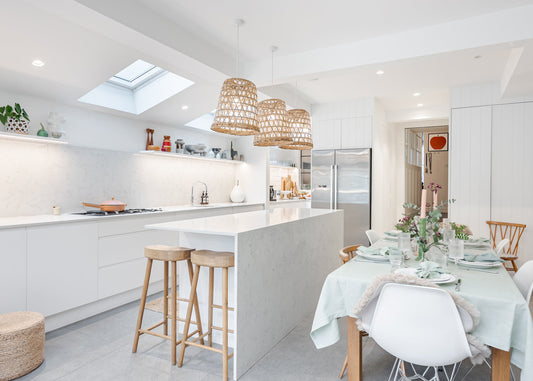 Modern kitchen with white island, stools, and dining table set.